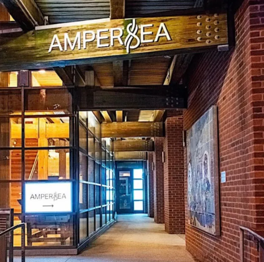 The illuminated Ampersea entrance on Thames Street in Baltimore at night